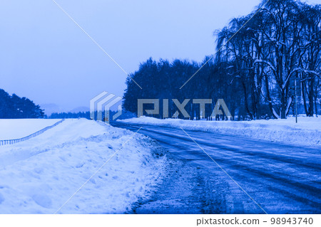 Photo Blue shadow of snow on the road after snow removal at Koiwai Farm after a heavy snowfall 98943740