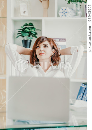 Office laptop woman. Calm smiling businesswoman relaxing on comfortable office chair hands behind head, happy woman resting in office satisfied after work, enjoying break, peace of mind, no stress 98943905