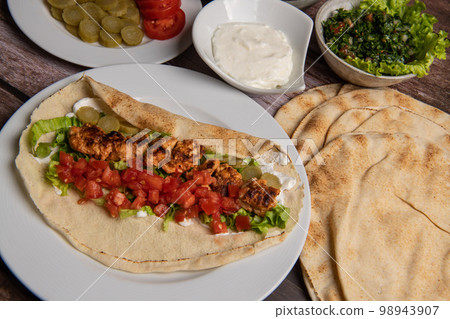 Lebanese recipe of chich taouk, garlic cream, toum, in a Lebanese bread, tabbouleh and chickpea 98943907