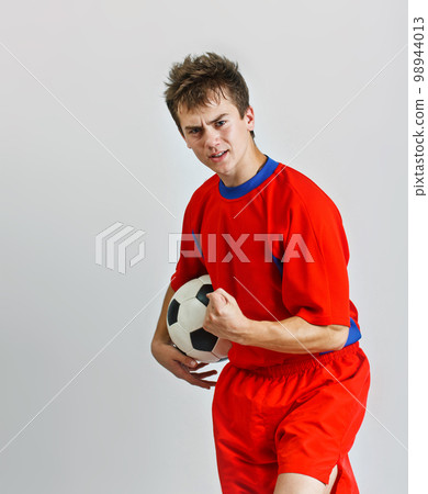 Young soccer player holding a ball 98944013