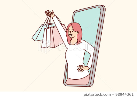 Happy woman peeking out of mobile phone screen raising hand with packages from clothing store 98944361