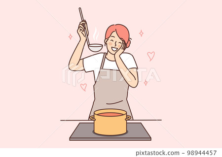 Happy housewife woman cooks soup standing at stove with saucepan and tastes after adding spices Happy housewife woman cooks soup standing at stove with saucepan and tastes after adding spices 98944457