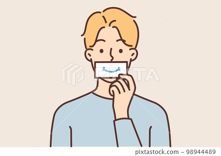 Man puts piece paper with image of smile to mouth, wanting to fake positive emotions during stress Man puts piece paper with image of smile to mouth, wanting to fake positive emotions during stress 98944489