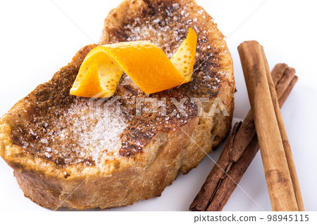 Traditional homemade Spanish torrijas decorated with cinnamon and Orange peel isolated on white background Traditional homemade Spanish torrijas decorated with cinnamon and Orange peel isolated on white background 98945115