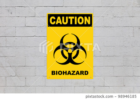 Caution, Biohazard sign on a cinder block wall 98946185