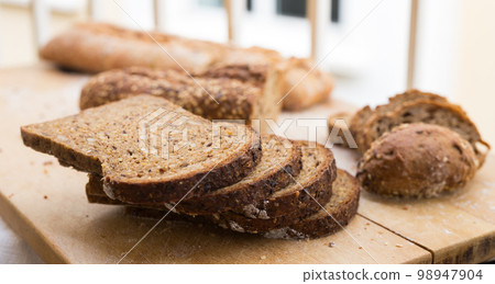 fresh loaf of bread on wooden board 98947904