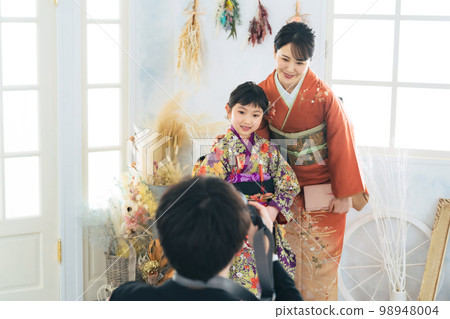 A photographer taking pictures of a parent and child in kimono Commemorative photo in kimono photo studio photo studio 98948004