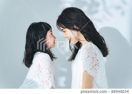 一個女人和一個女孩互相凝視 父母和孩子的美麗形象 一個女人和一個女孩互相凝視 父母和孩子的美麗形象 98948034