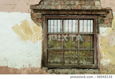 old broken window with bars in old buildings 98948138