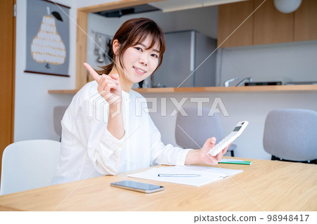 Young woman living room household account book Young woman living room household account book 98948417