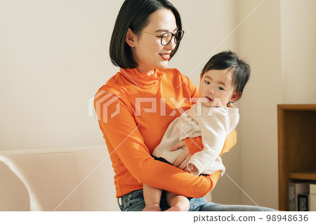 A mother holding a baby 98948636