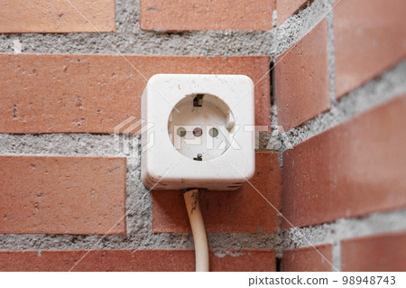 Old electrical socket on a brick wall close up 98948743
