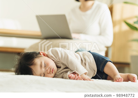 一個0歲的嬰兒在地毯上小睡 一個0歲的嬰兒在地毯上小睡 98948772