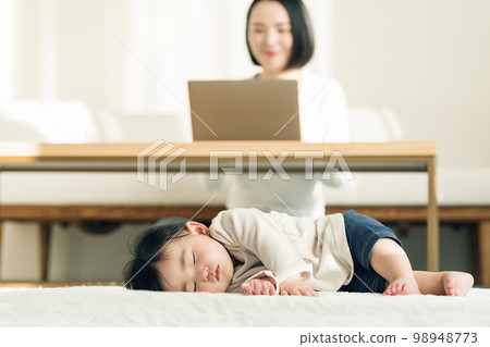 A 0-year-old baby taking a nap on a rug 98948773