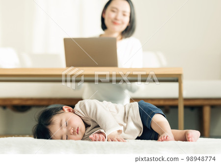 A 0-year-old baby taking a nap on a rug 98948774