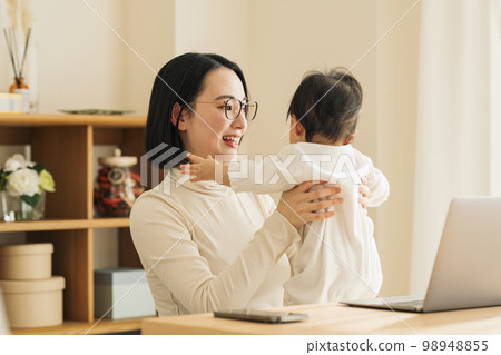 Women balancing work and childcare Women balancing work and childcare 98948855