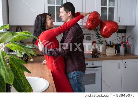 Man and woman in love date at home in kitchen happy hugs. Valentine's Day, happy couple, love story. Love nest, housing for young family 98949075
