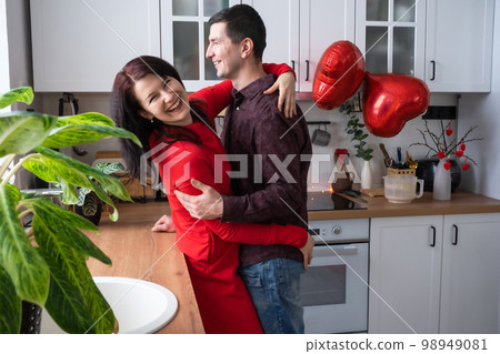 Man and woman in love date at home in kitchen happy hugs. Valentine's Day, happy couple, love story. Love nest, housing for young family 98949081