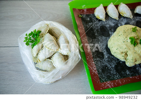 Raw green dough dumplings with parsley, dill. 98949232