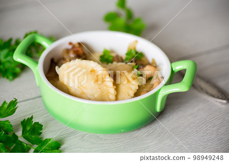 Potato dumplings with onion and mushrooms in a plate. Potato dumplings with onion and mushrooms in a plate. 98949248