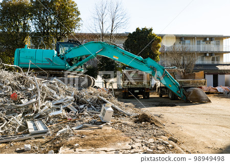 Housing complex demolition construction site Heavy equipment backhoe and dump truck Housing complex demolition construction site Heavy equipment backhoe and dump truck 98949498