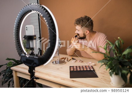 Man make up vlogger recording broadcast about cosmetics and tutorials for make-up artist 98950124