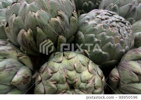 Stack of artichokes on a market stall 98950596