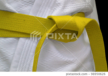 Yellow obi sash tied around a gi 98950626