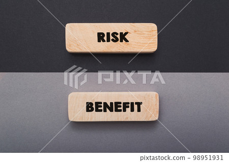 Words Risk and Benefit on board on grey and black background Words Risk and Benefit on board on grey and black background 98951931