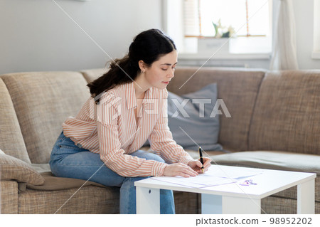 Purchase of real estate. Young caucasian woman fills documents in office. Concept of leasing, business and mortgage 98952202