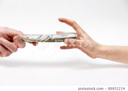 Man's hand offers dollar bribe, and a woman greedily reaches for money. Close-up. Concept of bribery and corruption 98952214