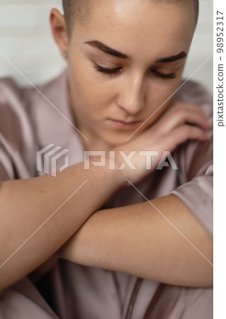 Portrait of unhappy pensive woman with cancer. 98952317