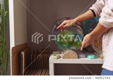 Female decorator hands place handmade epoxy resin tray on stand exposition 98952342