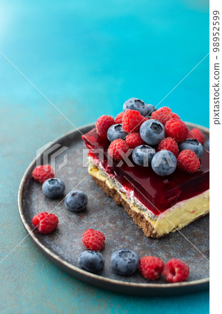 Piece of cheesecake with fruits 98952599