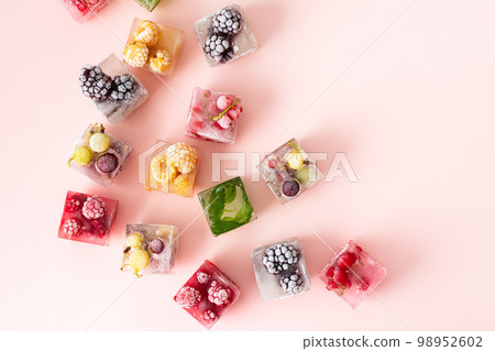 Frozen ice cubes with various berries Frozen ice cubes with various berries 98952602