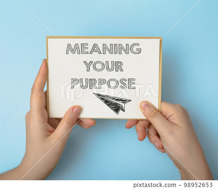 Person holds card with phrase Meaning Your Purpose on blue Person holds card with phrase Meaning Your Purpose on blue 98952653