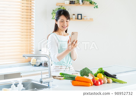 Smiley middle woman cooking in the kitchen 98952732