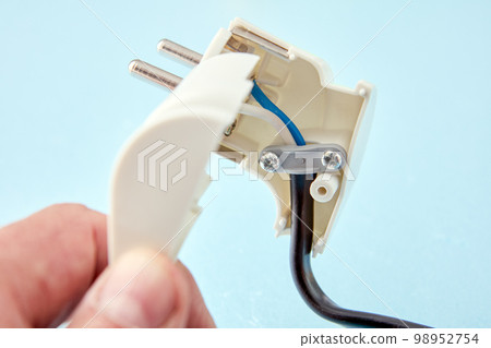 Disassembled European standard electric plug and an electrical cord connected to it. Disassembled European standard electric plug and an electrical cord connected to it. 98952754