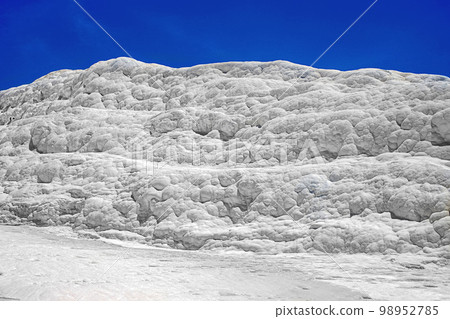 View of natural travertine pools and terraces in Pamukkale on a summer day. Texture of a white wall close-up 98952785