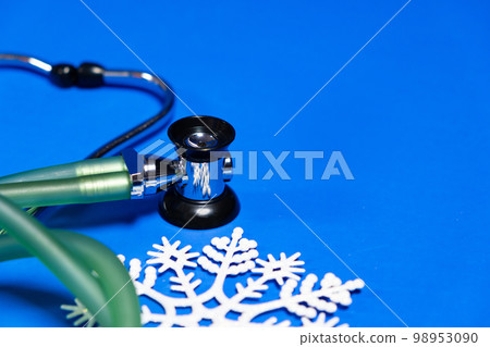 Christmas and New Year Medicine - Stethoscope and Snowflakes on a Blue Background, place for text. Christmas and New Year Medicine - Stethoscope and Snowflakes on a Blue Background, place for text. 98953090
