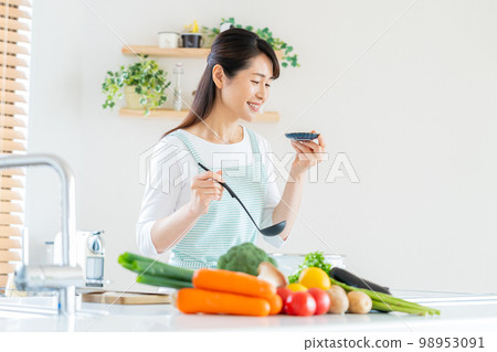 Smiley middle woman cooking in the kitchen 98953091
