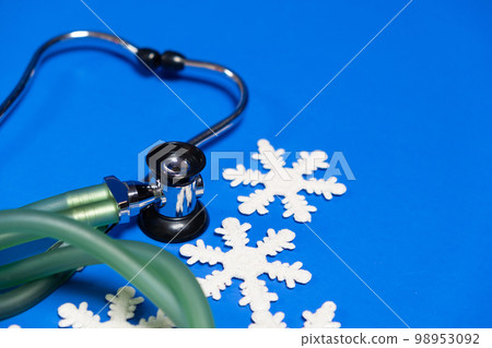 Christmas and New Year Medicine - Stethoscope and Snowflakes on a Blue Background, place for text. Christmas and New Year Medicine - Stethoscope and Snowflakes on a Blue Background, place for text. 98953092