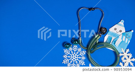 Christmas and New Year Medicine - Stethoscope, Snowmen and Snowflakes on a Blue Background, place for text. Christmas and New Year Medicine - Stethoscope, Snowmen and Snowflakes on a Blue Background, place for text. 98953094