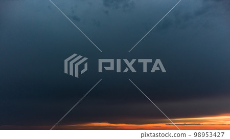 Epic dark cloudscape with orange sunset layers 98953427