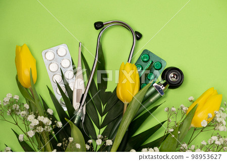 Bouquet of flowers and stethoscope on a green background, happy doctors day, nurses week and other medical holidays. 98953627