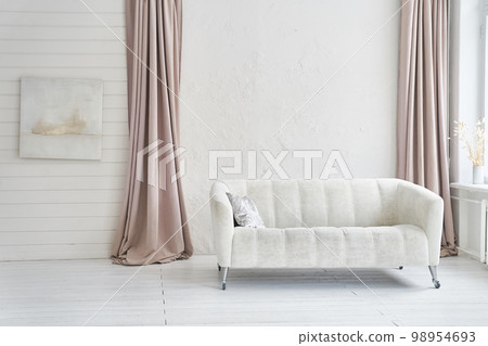 Stylish interior of the living room of a modern apartment with a white sofa and light curtains. Abstract paintings on the wall. Home decor with copy space. High quality photo Stylish interior of the living room of a modern apartment with a white sofa and light curtains. Abstract paintings on the wall. Home decor with copy space. High quality photo 98954693