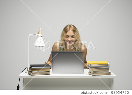 Cheerful office worker business student woman freelancer laughing in front of laptop while speaking with the partners or clients. Cheerful office worker business student woman freelancer laughing in front of laptop while speaking with the partners or clients. 98954730