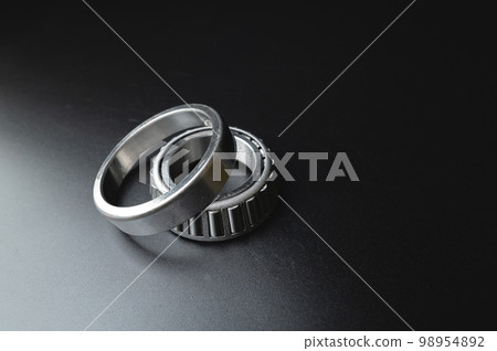 new two-piece roller bearing on a black background. Metal spare part for car suspension 98954892