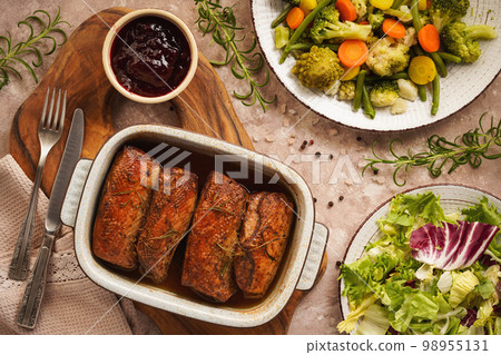 Roasted duck breasts served with vegetables and cranberry dip. 98955131
