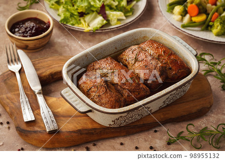 Roasted duck breasts served with vegetables and cranberry dip. 98955132